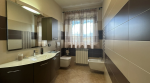 Bagno moderno con dettagli in tonalità marroni e pareti decorate. Spazio luminoso e accogliente.