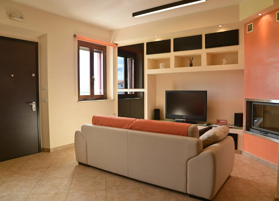 Soggiorno confortevole con divano e televisore, ideale per momenti di relax.