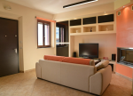 Soggiorno confortevole con divano e televisore, ideale per momenti di relax.