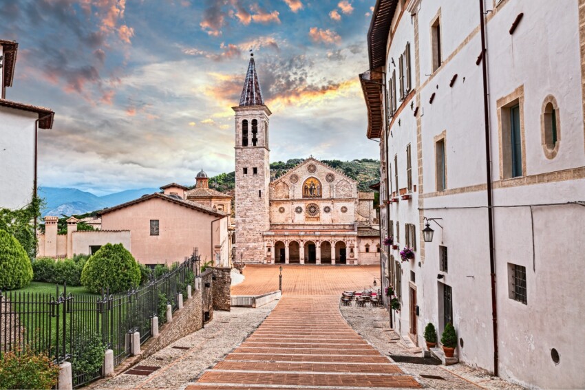 Panorama di Spoleto, in Umbria con il duomo e un paesaggio montano visibile sullo sfondo.