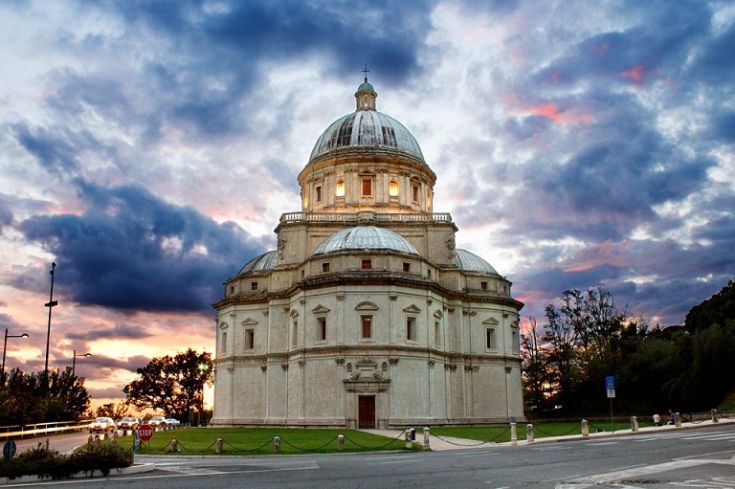 Tempio di Santa Maria della Consolazione, circondato dal prato e da un cielo nuvoloso.