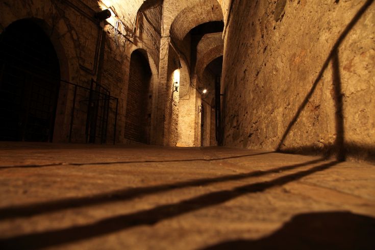 Un corridoio in pietra con archi che comunica un'atmosfera storica e suggestiva.