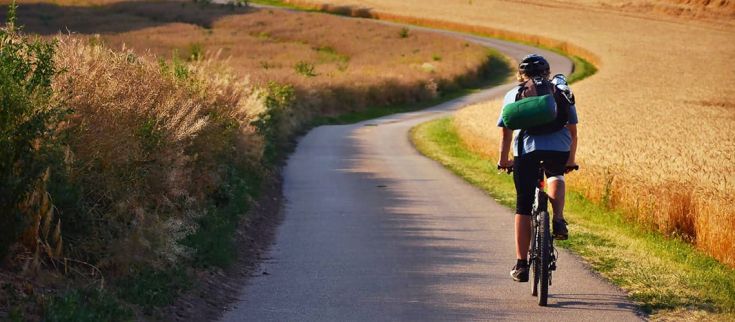 Un ciclista percorre una strada tranquilla immersa nella natura dell'Umbria.