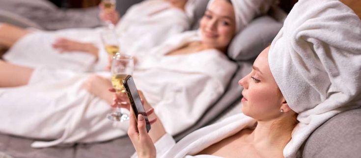 Un momento di relax in un centro benessere con amiche, gustando champagne e condividendo bei momenti insieme.
