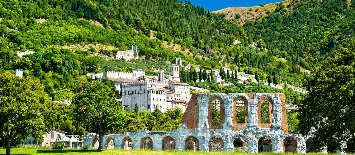 Un paesaggio dell'Umbria con rovine storiche immerse nel verde circostante.