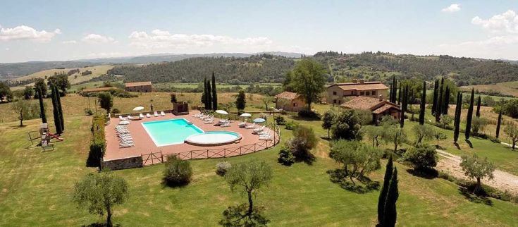 Panorama di una villa tranquilla in Umbria con piscina, circondata da verde e dolci colline.
