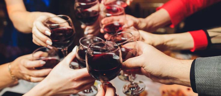 Un brindisi semplice con calici di vino rosso, che rappresenta l'unità e un momento di festa.