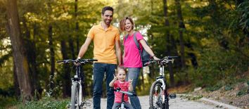 Vacanza in bici per famiglie con bambini sulle colline umbre. Green Experience Family Umbria my Love - Una famiglia si diverte durante una giornata di ciclismo immersa nel verde.