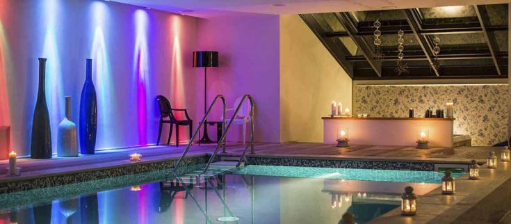 Un centro benessere con piscina, illuminato da luci soffuse, per momenti di relax e tranquillità.