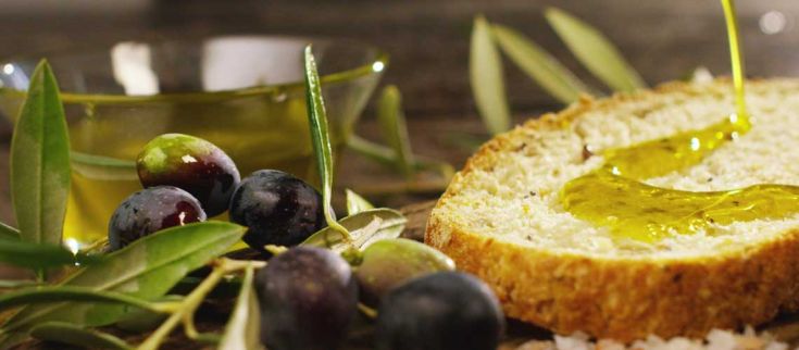 Fette di pane croccante condite con olio d'oliva e olive fresche, un'esperienza culinaria tipica dell'Umbria.