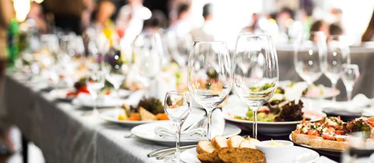 Un banchetto elegante allestito con diversi piatti, bicchieri e una piacevole atmosfera sociale.