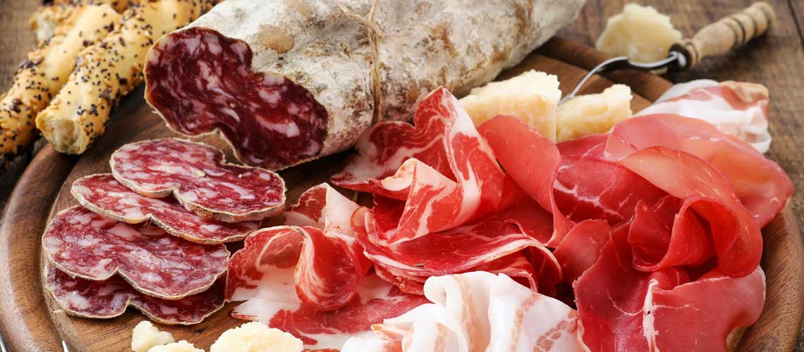 Un assortimento di salumi umbri su un tagliere di legno, un piacere semplice per il palato.