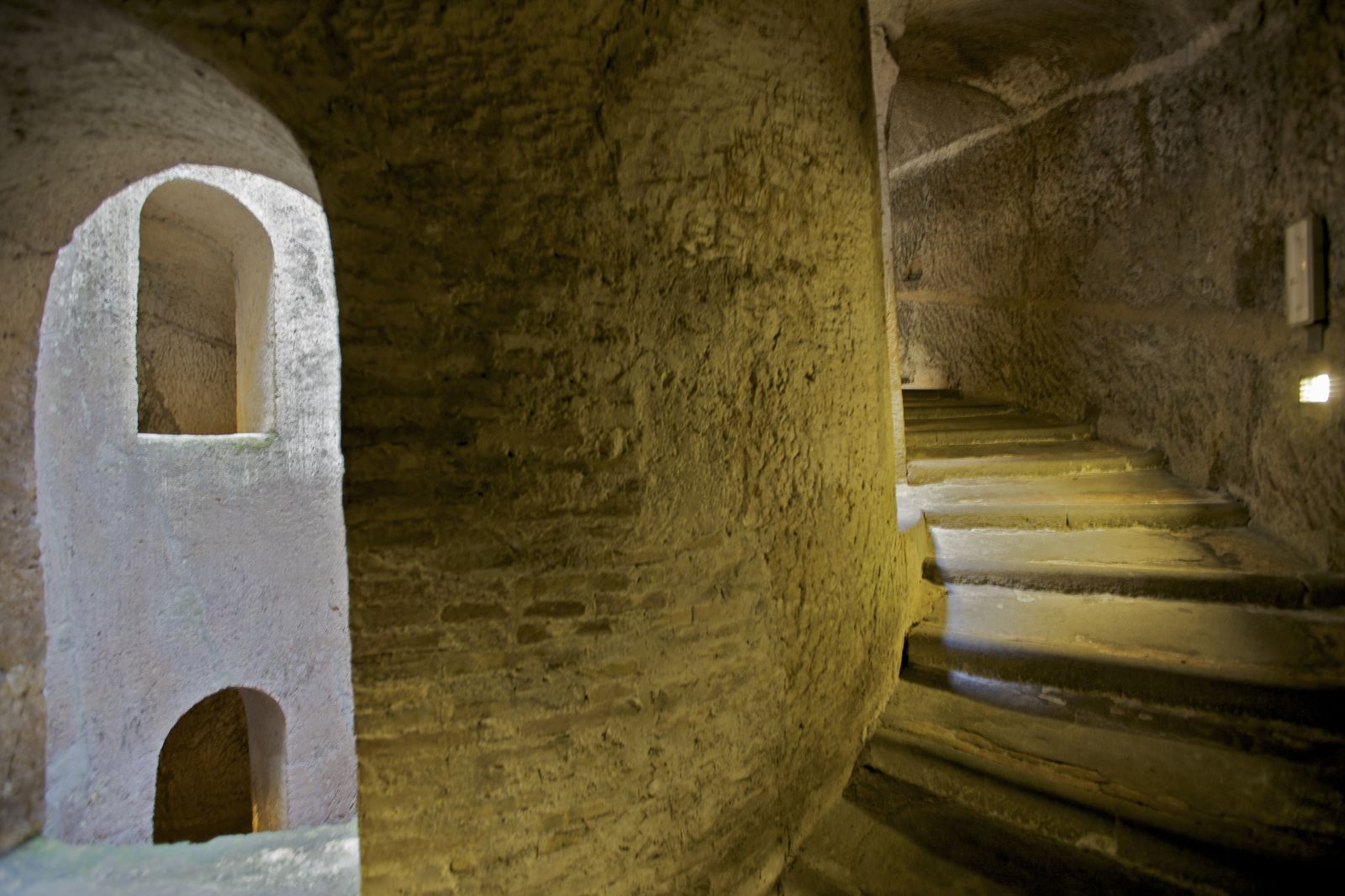 Scala in pietra che presenta scale e aperture storiche, tipico dell'architettura del pozzo di San Patrizio a Orvieto.