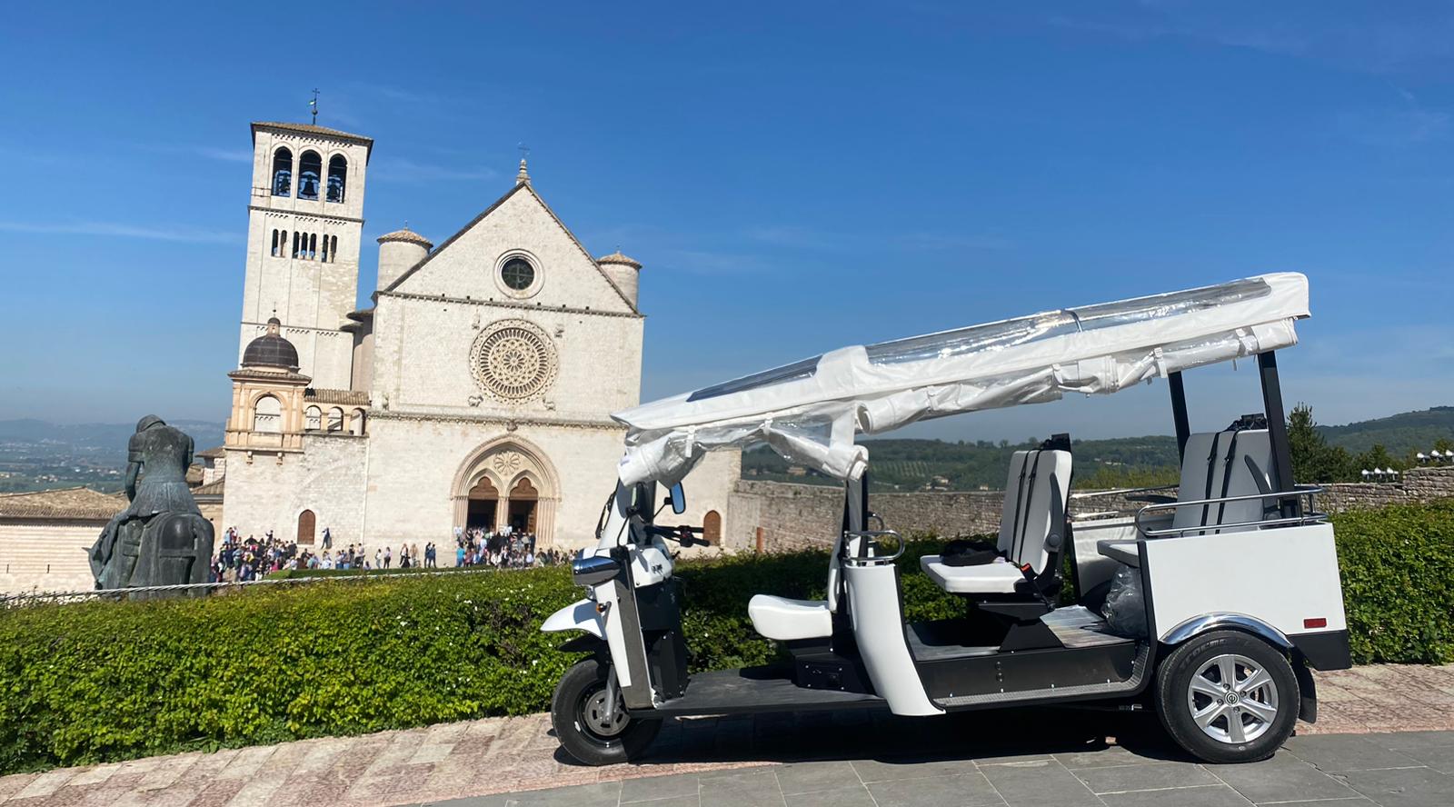 Un veicolo ecologico posizionato davanti al Palazzo di San Francesco, un noto simbolo architettonico. Ideale per visitare il centro storico.