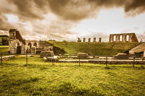 Rovine storiche che mostrano la bellezza di un antico teatro. La natura intorno arricchisce il panorama.