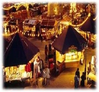 Vista di sera di mercatini di Natale, caratterizzato da bancarelle illuminate che offrono prodotti locali e cibo delizioso.