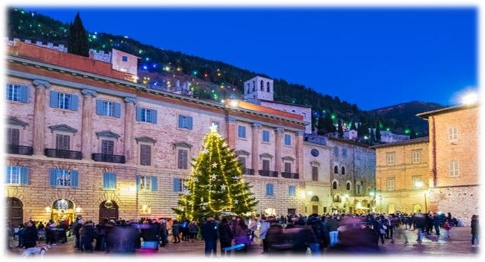 Una piazza festosa decorata per il Natale, con un albero di Natale e molte persone che si godono l'atmosfera.