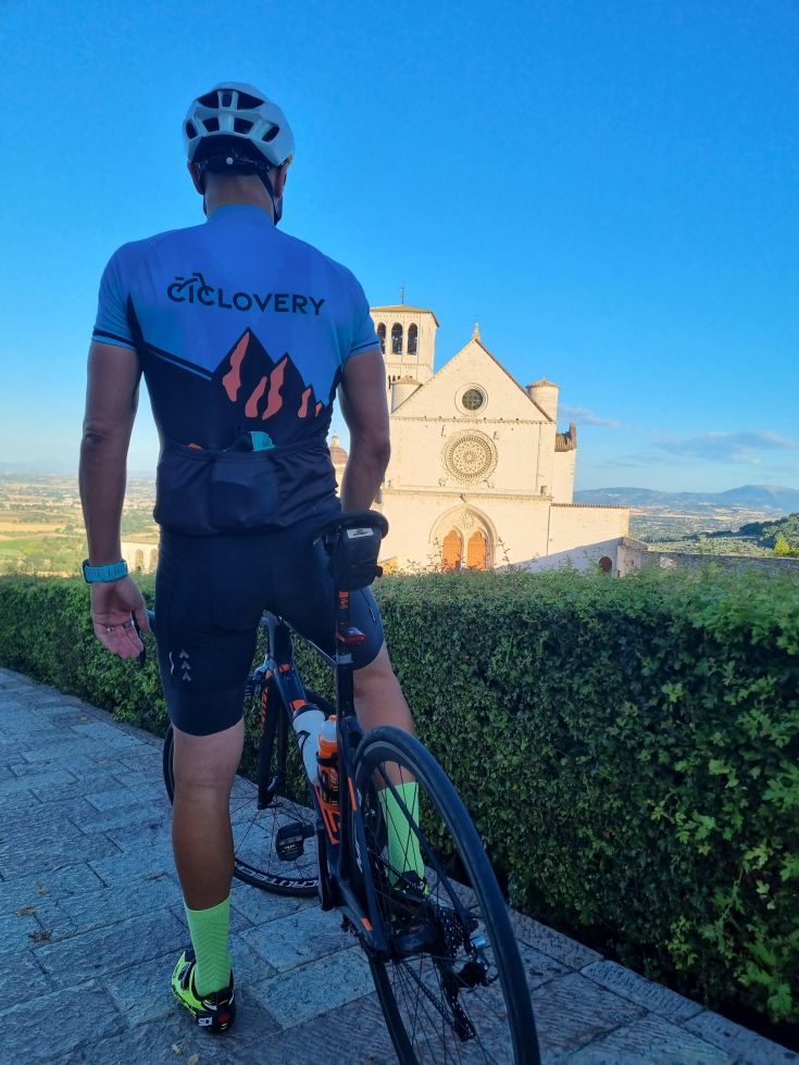 Ciclista in pausa, osserva il panorama di un tranquillo paesaggio umbro.