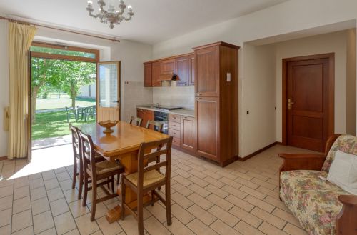 Cucina semplice con panoramica su un giardino verde, adatta per un soggiorno in famiglia.