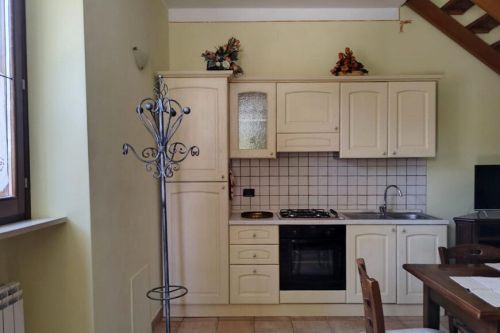 Cucina spaziosa e attrezzata, caratterizzata da un'illuminazione naturale che crea un'atmosfera serena.