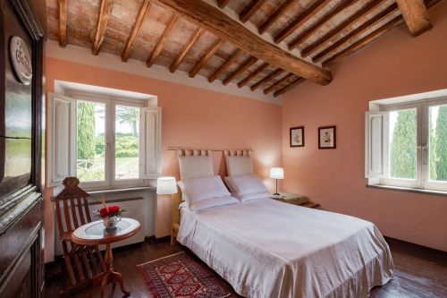 Camera dal design sobrio e confortevole, con grandi finestre che si affacciano sulla campagna umbra.