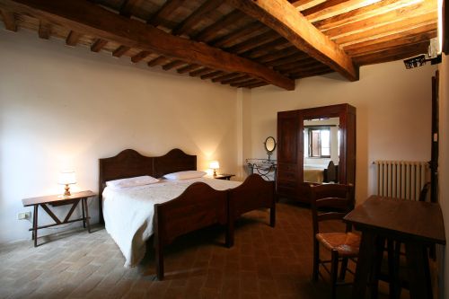 Camera in legno caratterizzata da letti matrimoniali e arredi semplici, ideale per un soggiorno tranquillo.