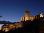 La Basilica di San Francesco di Assisi si distingue nel panorama notturno con la sua architettura storica ben visibile.