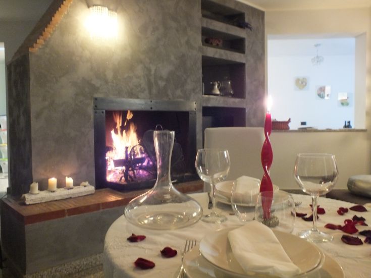 Una cena accogliente a lume di candela con camino e dettagli semplici.
