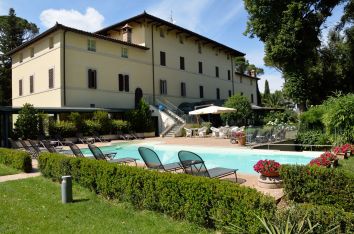 Villa con piscina e giardino circondata da aree verdi, adatta per una vacanza estiva rilassante.