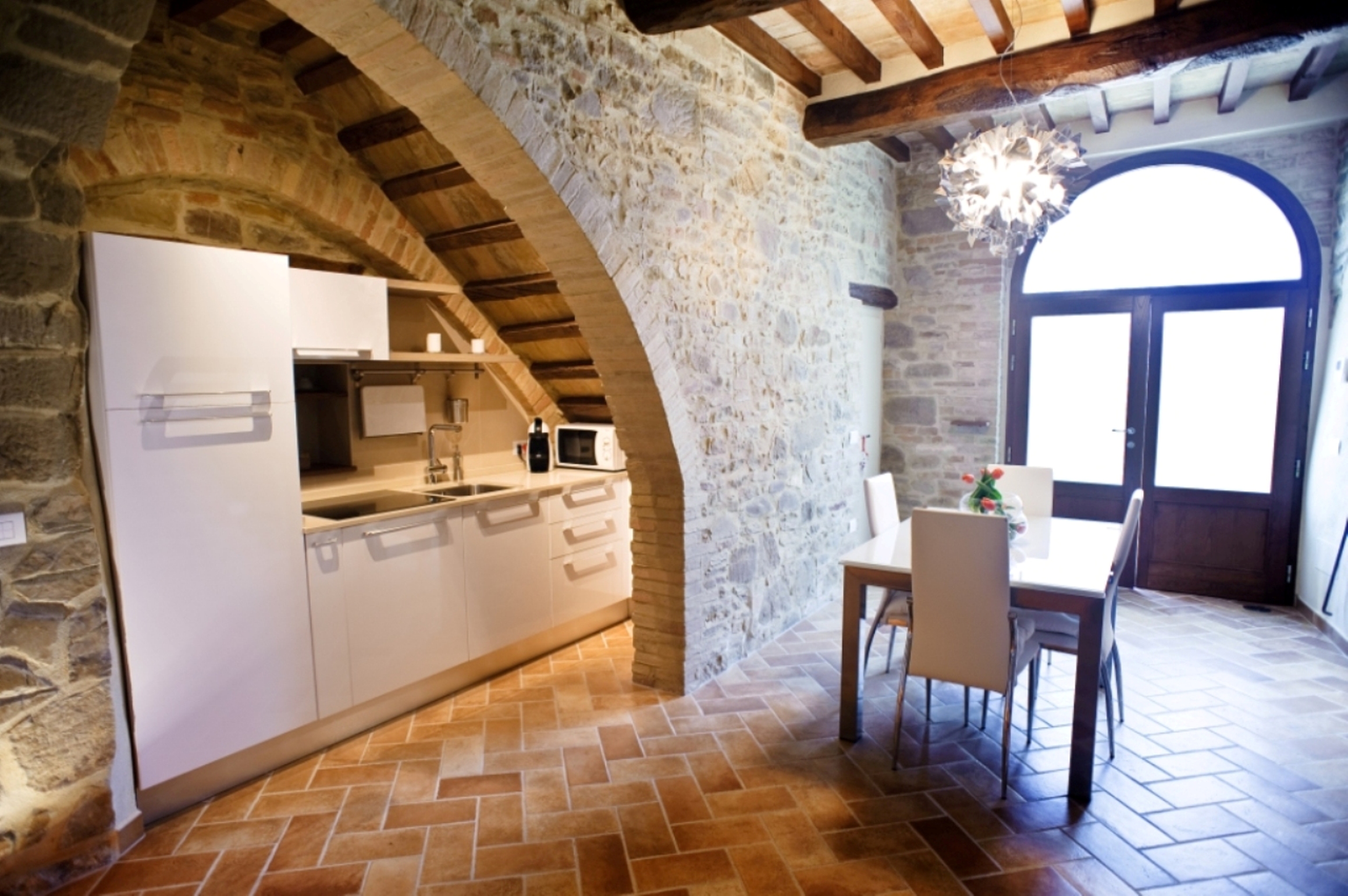 Cucina moderna in un appartamento ristrutturato, con dettagli storici e un'atmosfera calda.