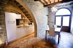 Cucina moderna in un appartamento ristrutturato, con dettagli storici e un'atmosfera calda.
